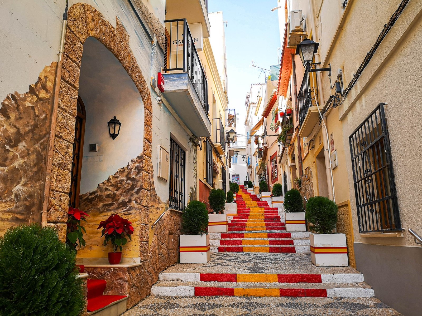 Red and yellow painted steps on Carrer de Puchalt in Calpe Old Town