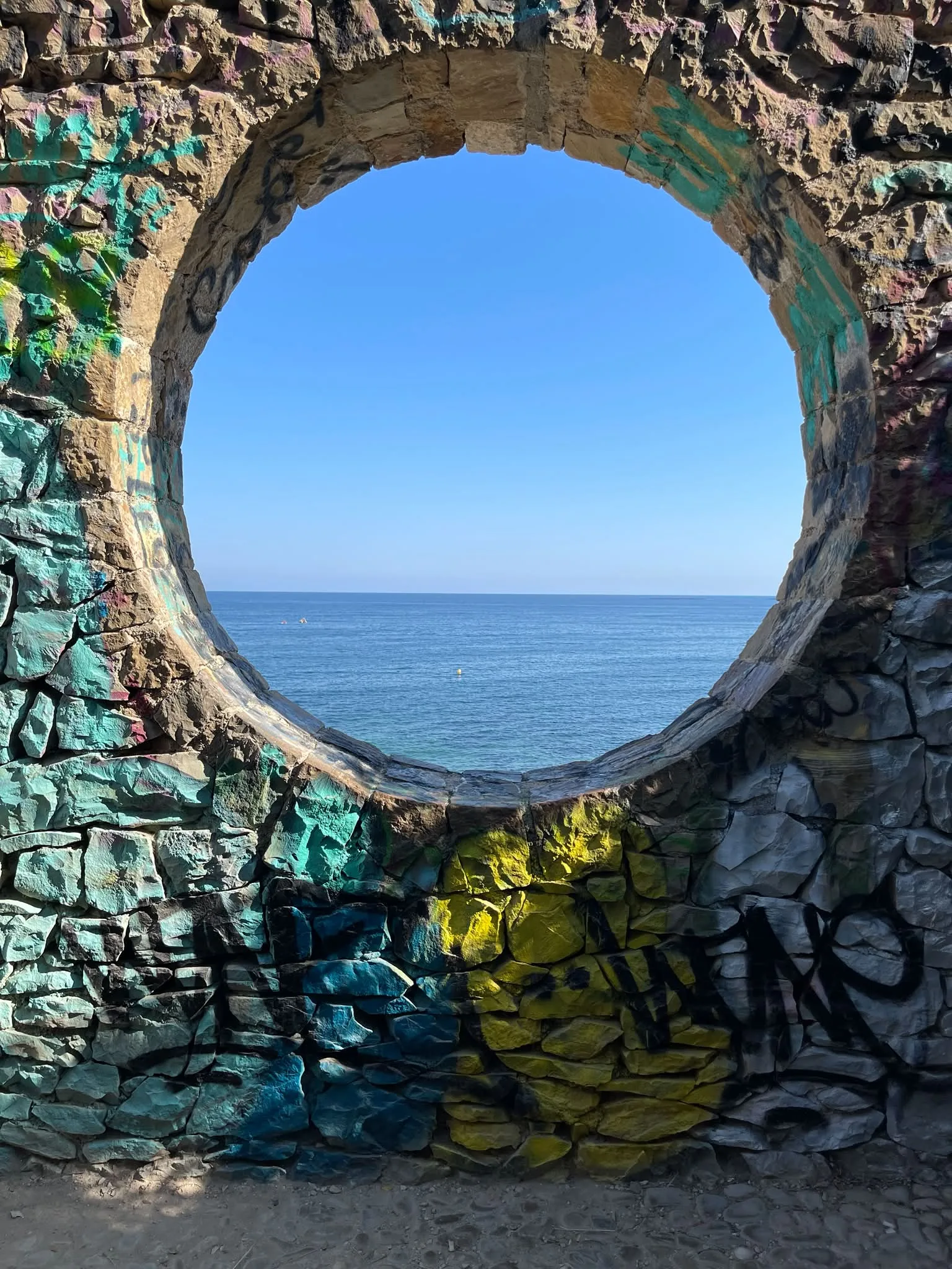Mediterranean Sea framed by a colourful stone opening in Calpe