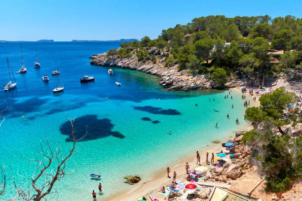 Crique turquoise d?Ibiza avec bateaux et plage abrit?e