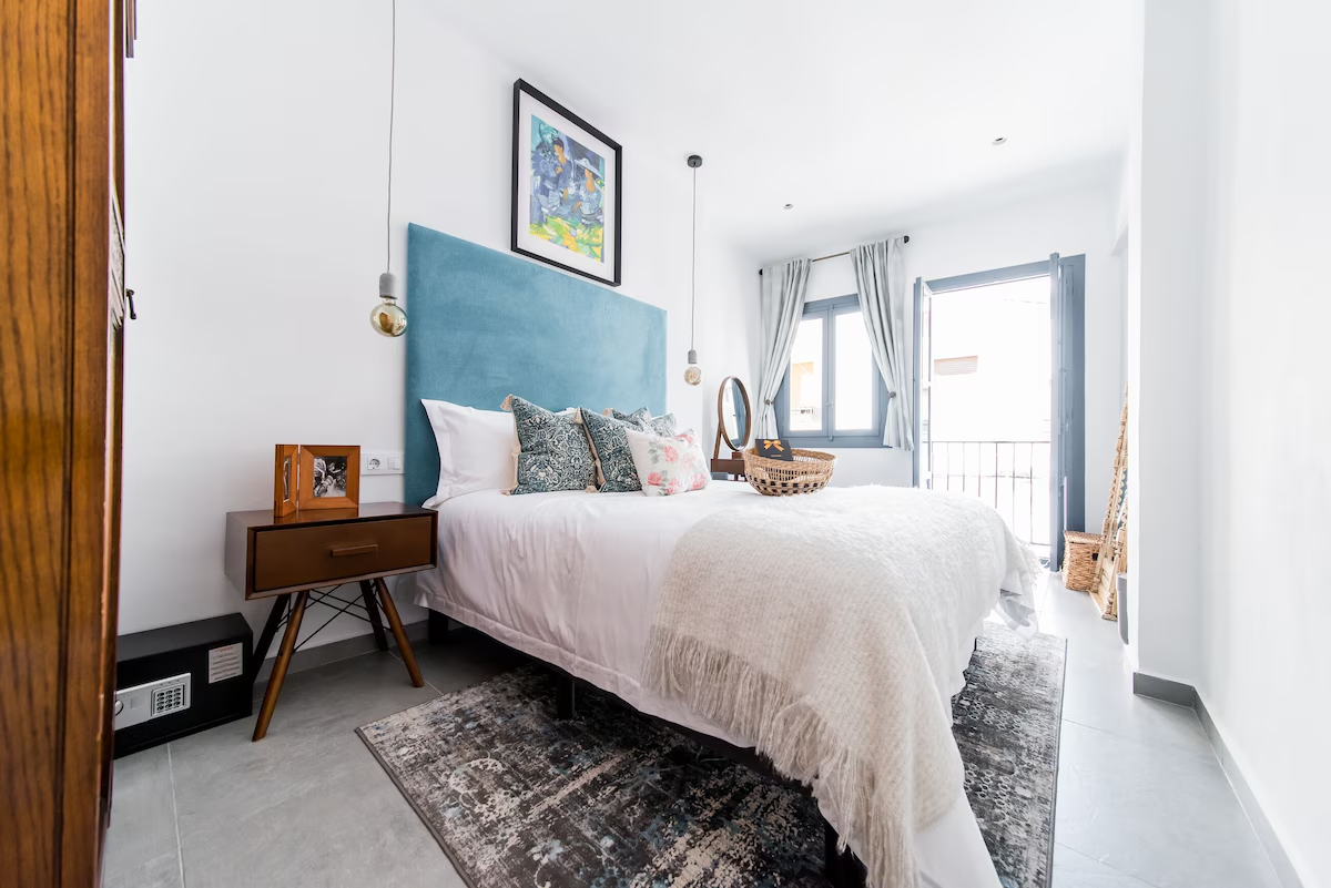 Casa Toro bright bedroom with blue headboard and balcony doors