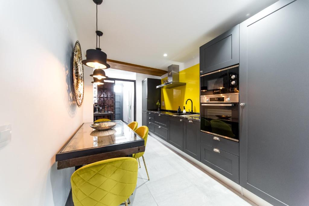 Casa Toro kitchen and dining space with yellow chairs and black cabinetry